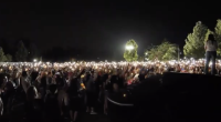 Hundreds of people hold up candles at knight in Marketplace park to honor Charlie Kirk.
