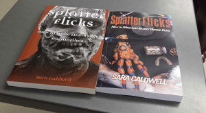 Two books titled Splatter Flicks: How to Make Low-Budget Horror Films by Sara Caldwell are placed side by side on a gray surface. The book on the left has a red cover featuring a close-up of a zombie-like face in black and white. The book on the right, labeled “Revised & Expanded,” shows a cover with a monster hand prop, a jar of preserved objects, and prosthetic teeth on a dark background.