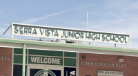 The front entrance of Sierra Vista Junior High School showing the school’s name sign above the building and a “Welcome” sign on the glass doors of the administration building.