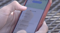 A person holds a smartphone with a red case, using a ride-planning app that displays “Plan your ride” and location options such as “Canyon Country Park” and “17615 Soledad Canyon Rd” on the screen.