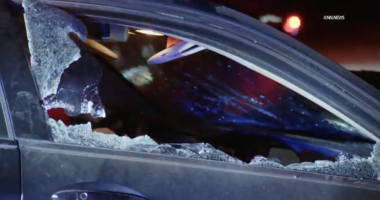 Broken passenger side window of a dark sedan that was in a car accident.